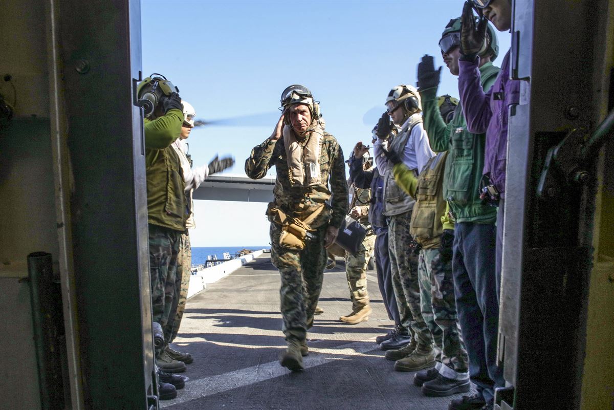 The commander of U.S. Africa Command salutes sideboys as he arrives on a ship.