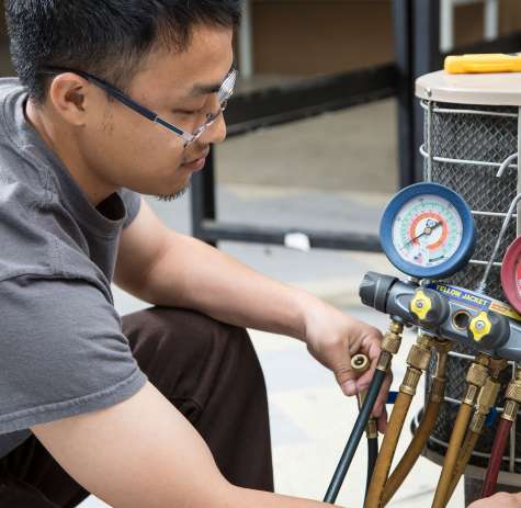 HVAC student working on a air conditioner