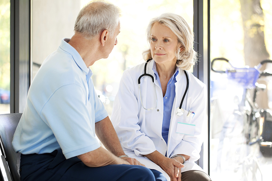 Elderly male patient talking with female doctor