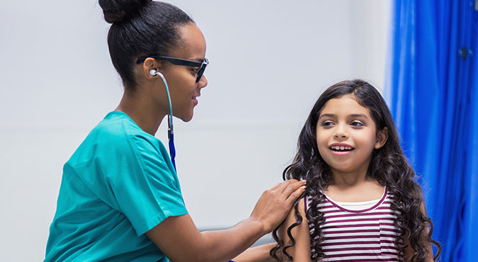 Dr examining young girl with a stethoscope