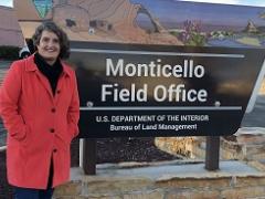 lady in red coat standing in front of Monticello FO sign