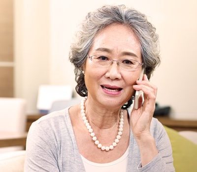 An elderly woman talking on a cellphone