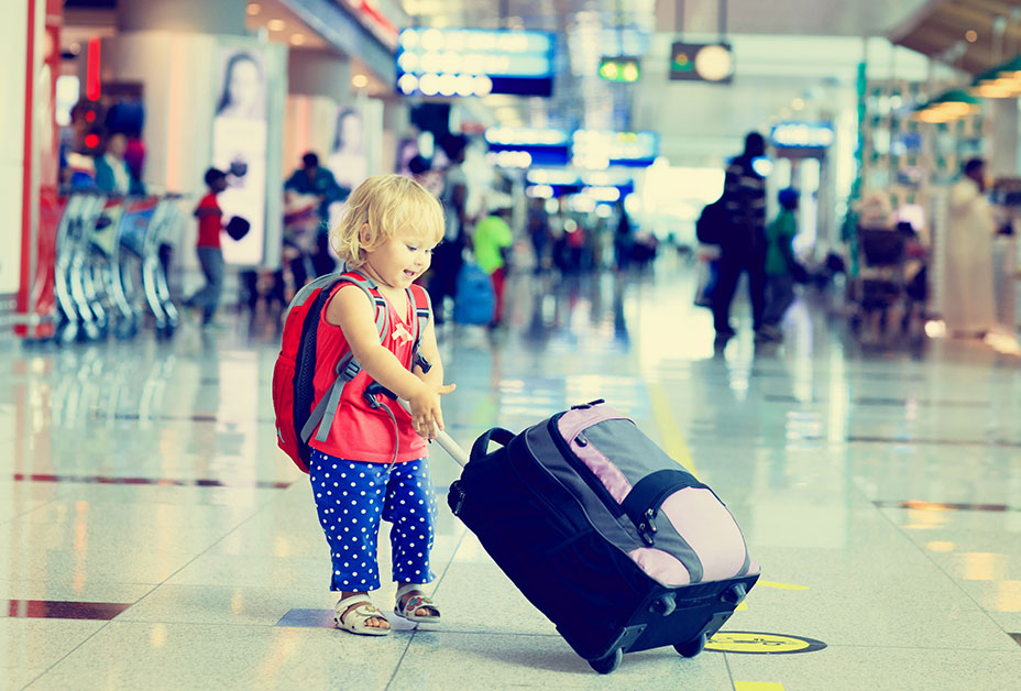 Young girl pulling suitcase through airport