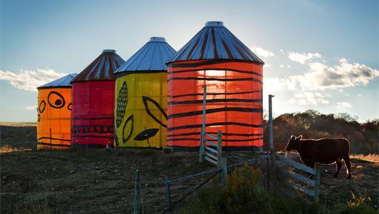 Cribs by Brenda Baker. Illuminated silo-esque structures