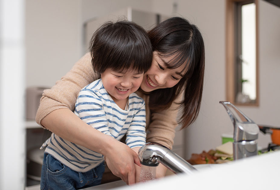 Mom and child washing hands and smiling