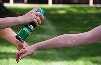 Insect repellent being sprayed onto a person's arm