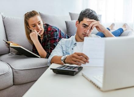 young couple at computer look concerned