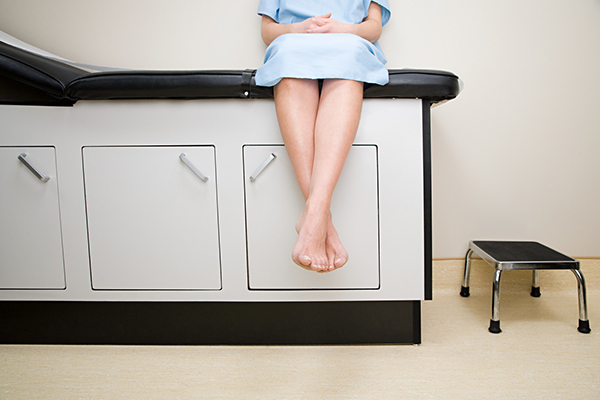 Patient sitting on table in doctor's exam room