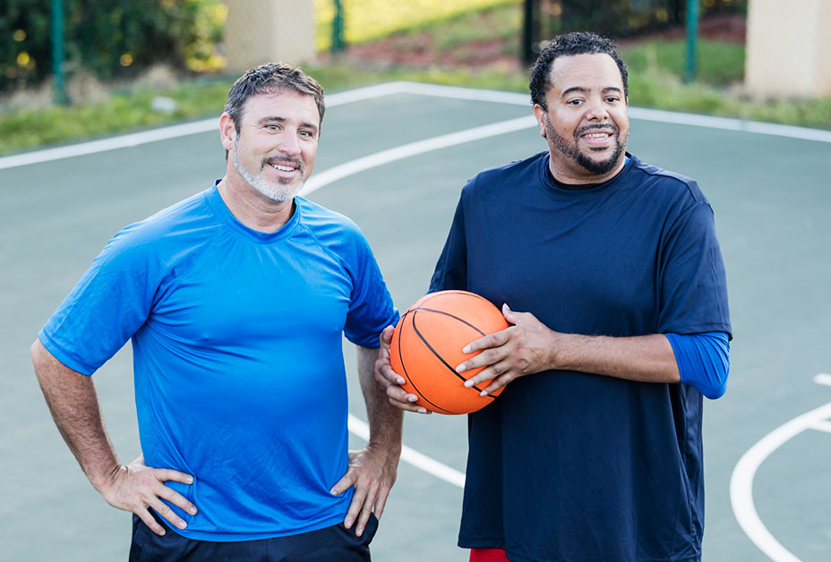 Two older men playing basketball