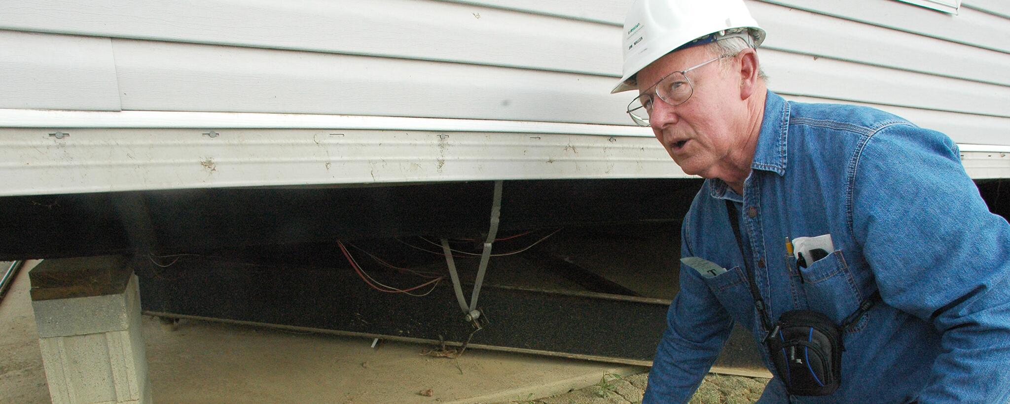 A researcher from Texas Tech University's Wind Science Research Center looks at mobile home tie-downs to help develop safer structures.