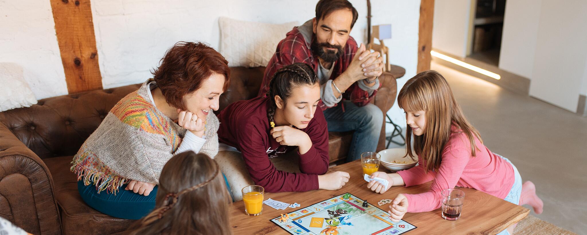 a family gathers around a table playing a board game
