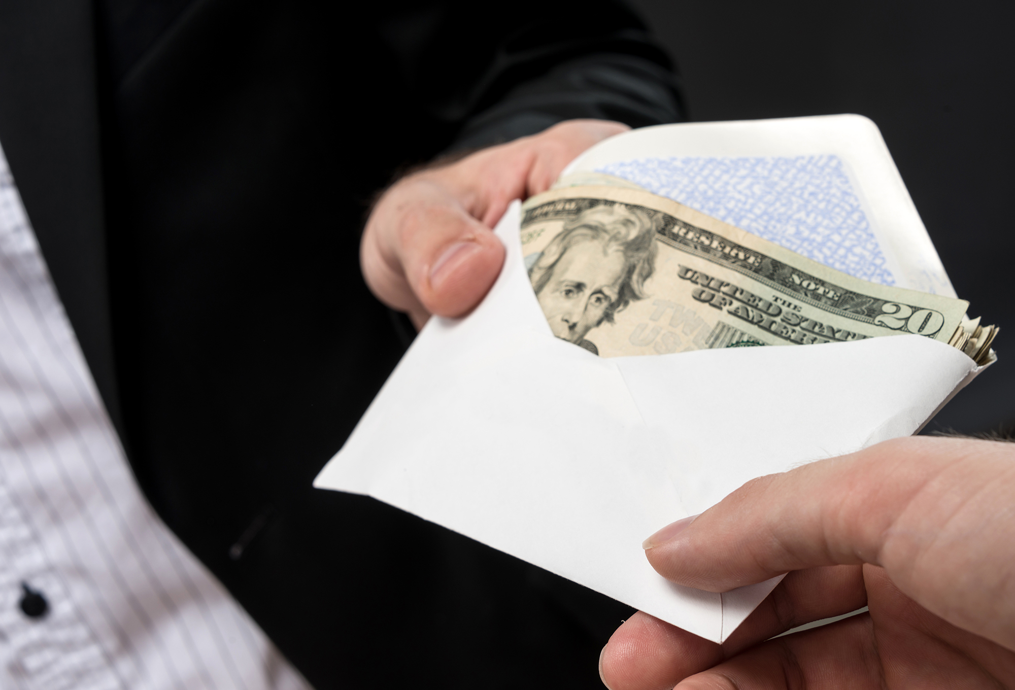 People Exchanging Envelope Full of Money (Stock Image)