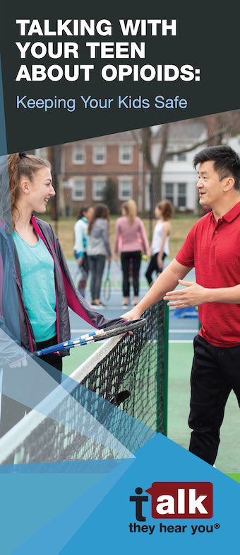 adult and teen talking on a tennis court