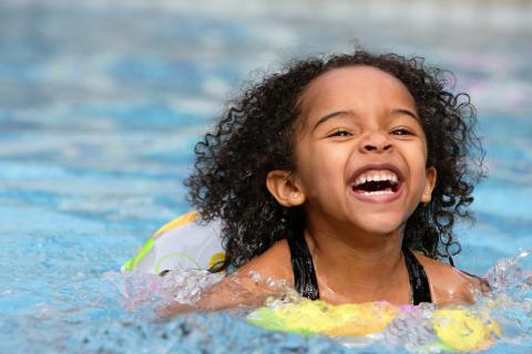 Happy child on the inner tube in the swimming pool