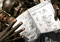 Sudanese refugee Sadir Ibrahim, 15, displays a schoolbook containing his drawings depicting the scenes of fighting he witnessed in Darfur, at the Iridimi refugee camp near Iriba in eastern Chad, Saturday, Sept. 25, 2004. (AP Photo/Ben Curtis)