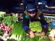 A woman selling greens at the market 