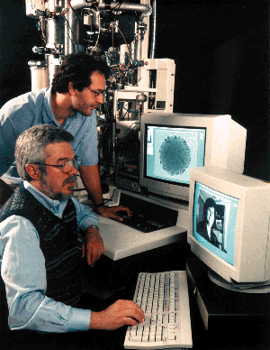 Larry Allard (seated) and Edgar Voelkl demonstrate the remote operation of an electron microscope.