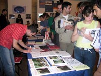 Interested students pick up information from a university booth at the exposition of U.S. universities, October 10, 2004