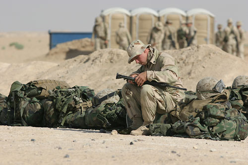 Photo of Cpl. Jon G. Tackett cleaning his rifle at Udairi Range, Kuwait Sept. 19.  Photo by Staff Sgt. J. D. Cress.