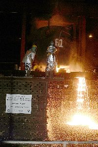 Workers from the Amite foundry pour molten steel recycled from the World Trade Center, into the mold of the bow stem of the Amphibious Transport Dock ship USS New York (LPD 21)