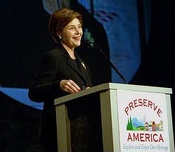 First Lady Laura Bush speaks at a podium that features the Preserve America Logo