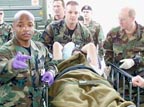 Staff Sgt. Jermain Smith, a medical technician from the 74th Medical Operations Squadron, left, helps other medics move an unidentified soldier from Operation Iraqi Freedom.