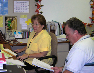 Picture of Debbie Percival and Jim Joyner discussing a caller's question at the e-Payroll Customer Support Center.