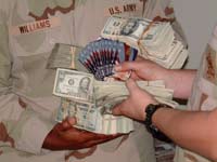 Image of a soldier holding cash and stored value cards.
