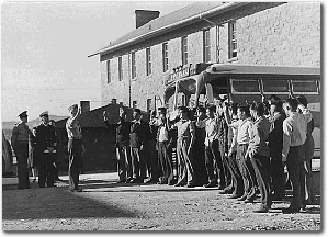Black and white photo of several Navajo Code Talkers being sworn in at an outdoors ceremony.