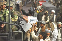 Afghan National Army soldiers distribute leaflets with information on voting in the upcoming elections in the streets of Kandahar, Afghanistan on Oct. 8, 2004. [AP/Wide World Photos.]