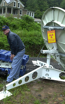 A FEMA communications specialist is shown setting up a satellite dish. FEMA photo.