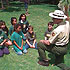 Link to volunteer and employment information - picture of volunteer ranger  Ed Bonsey giving a talk to school children