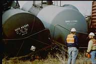 Photo: two derailed tankcars lie close together.