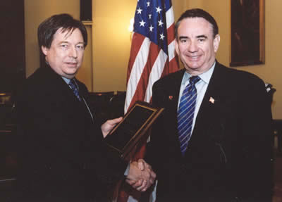 Graphic: Secretary Tommy G. Thompson receives the American Society of Transplantation (AST) 2003 Congressional Transplantation Public Policy Award from AST President William Harmon, MD at the group's Washington, DC, reception. 