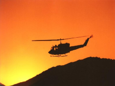 Uh1n helicoptor flying into the sunset