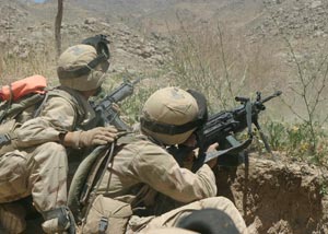An automatic rifleman from Charlie Co., Battalion Landing Team 1st Bn., 6th Marines, the ground combat element of the 22nd Marine Expeditionary Unit (Special Operations Capable), engages Taliban insurgents entrenched on a mountain with his M-249 squad automatic weapon during Operation ASBURY PARK in central Afghanistan.  The Marine to the left is using pre-determined hand signals in the form of pats on the back to guide the SAW gunner's fire. Photo by: Gunnery Sgt. Keith A. Milks