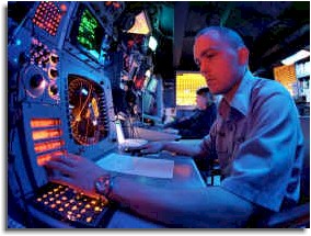 An Electronic Warfare Technician operates part of the Advanced Combat Direction Systems (ACDS) in the Electronic Warfare (EW) Module aboard USS Kitty Hawk (CV-63). 