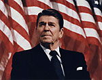 President Reagan standing in front of the American flag.