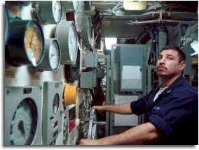 A Machinist's Mate makes adjustments to the boiler temperature aboard USS Kitty Hawk (CV 63). 
