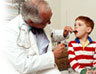 A doctor taking the temperature of a little boy