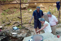 Georgia State Museum Director, David Lordkipanidze (replica skull in hands) points out bones under excavation at the Dmanisi dig to Ambassador and Mrs. Minikes 