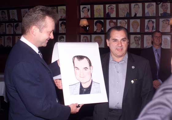 Max Klimavicius, the general manager of Sardi's Restaurant presents the newest addition to their Wall of Fame. Joe Lisi, a former Marine, is the recipient. This honor is equaled only by getting a star on the Hollywood Walk of Fame. Photo by: Gunnery Sgt. John S. Jamison Jr.