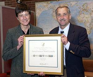 Dr. Catherine Verfaillie accepts a plaque from NIDCD director Dr. James Battey