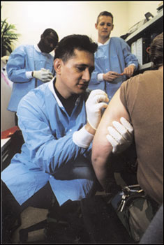A technician at Walter Reed Army Medical Center immunizes a Soldier against smallpox in 2002 when the inoculation program began. The program has now expanded to require vaccinations for Soldiers going to 17 additional high threat countries.