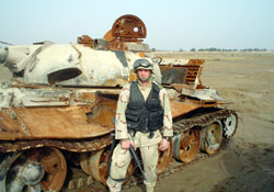 SOUTHWEST ASIA (AMCNS) -- Airman 1st Class Steven Stone stands in front of an Iraqi tank during a recent deployment working with Coalition forces to clear the area of munitions left over from the Iraqi conflict. (Courtesy photo)