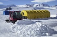 A tracked vehicle pushing snow.