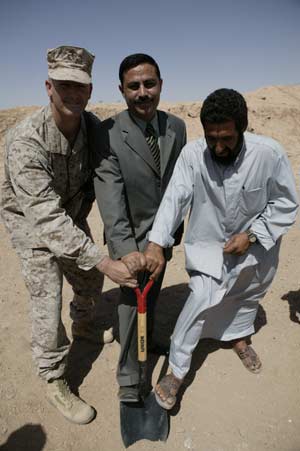 From left to right, Lt. Col. Milt Wick, commander of 3rd Battalion, 24th Marine Regiment, Thaer Handala, the local Iraqi government representative for the Khaldyah district, and the village leader of Al Kabani, Iraq, broke ground for a water purification system that will bring clean water to two villages and as many as 3,000 people near Camp Taqaddum on June 8, 2004. The $146,000 project was funded by a Coalition Provisional Authority program that allows commanders to identify and support civil affairs projects in their areas. Handala plans to hire local Iraqis to construct the system, while Marines will visit the site regularly to ensure the work is satisfactory. The job is expected to be completed by the end of June. Elements of the battalion provide security for the 1st Force Service Support Group at the camp. Wick, 42, is from Winfield, Kan. Photo by: Sgt. Matt Epright