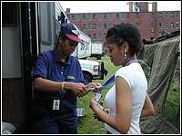 Photo of a FEMA working assisting a woman.