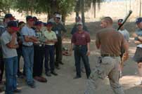 Master Sgt. Chris Cortazzo from the 416th Civil Affairs Battalion demonstrates to Iraqi youth the proper way to swing a bat in the American game of baseball.  The Soldiers taught youth from Al Kush, Iraq, the basic rules of the game in Mosul.
