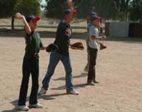 Iraqi youth practice throwing baseballs to each other in Mosul.  The members of a youth athletic club in Al Kush are learning to play the American sport of baseball.